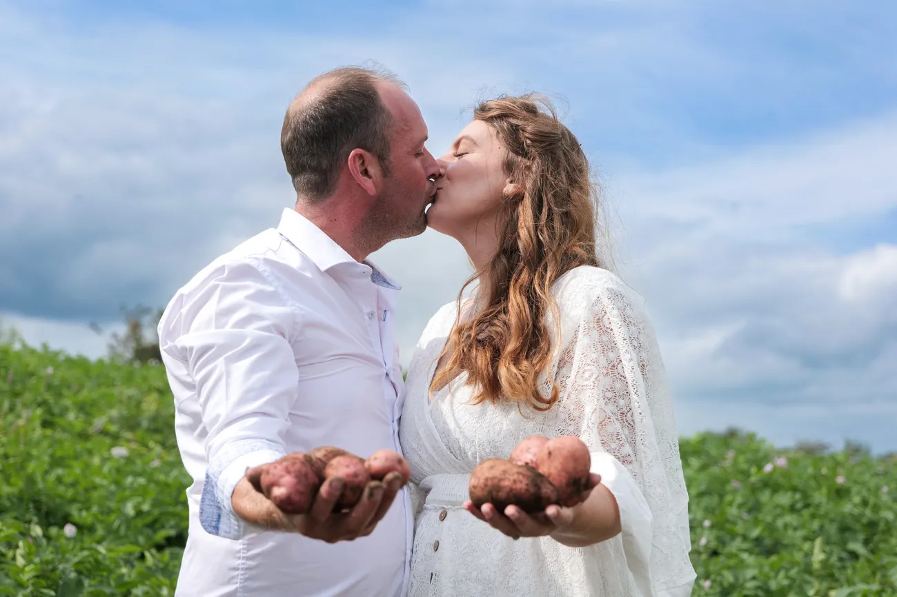 Countryside wedding kiss with palms held out