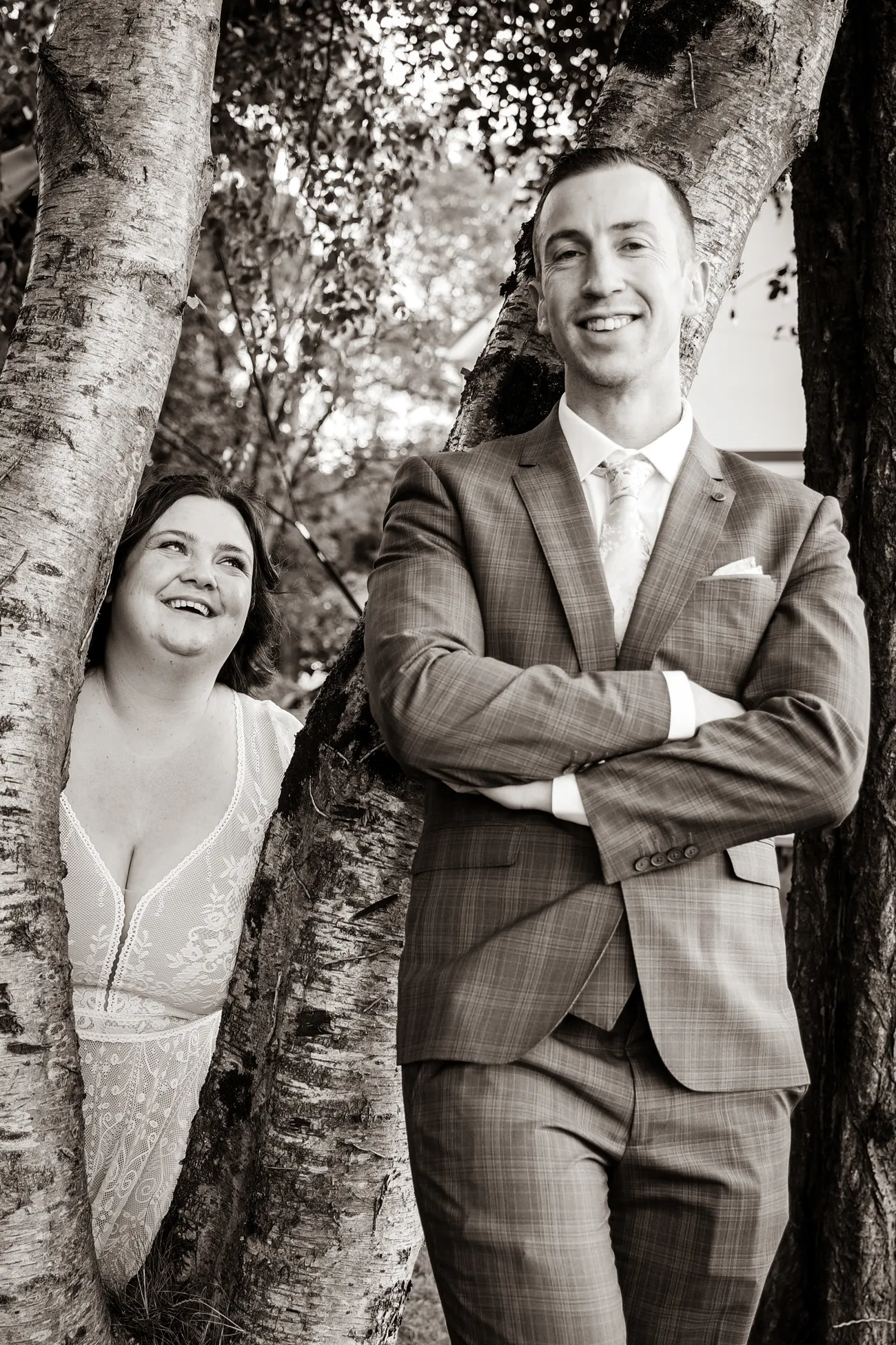 Black and white couple portrait peeking around a tree