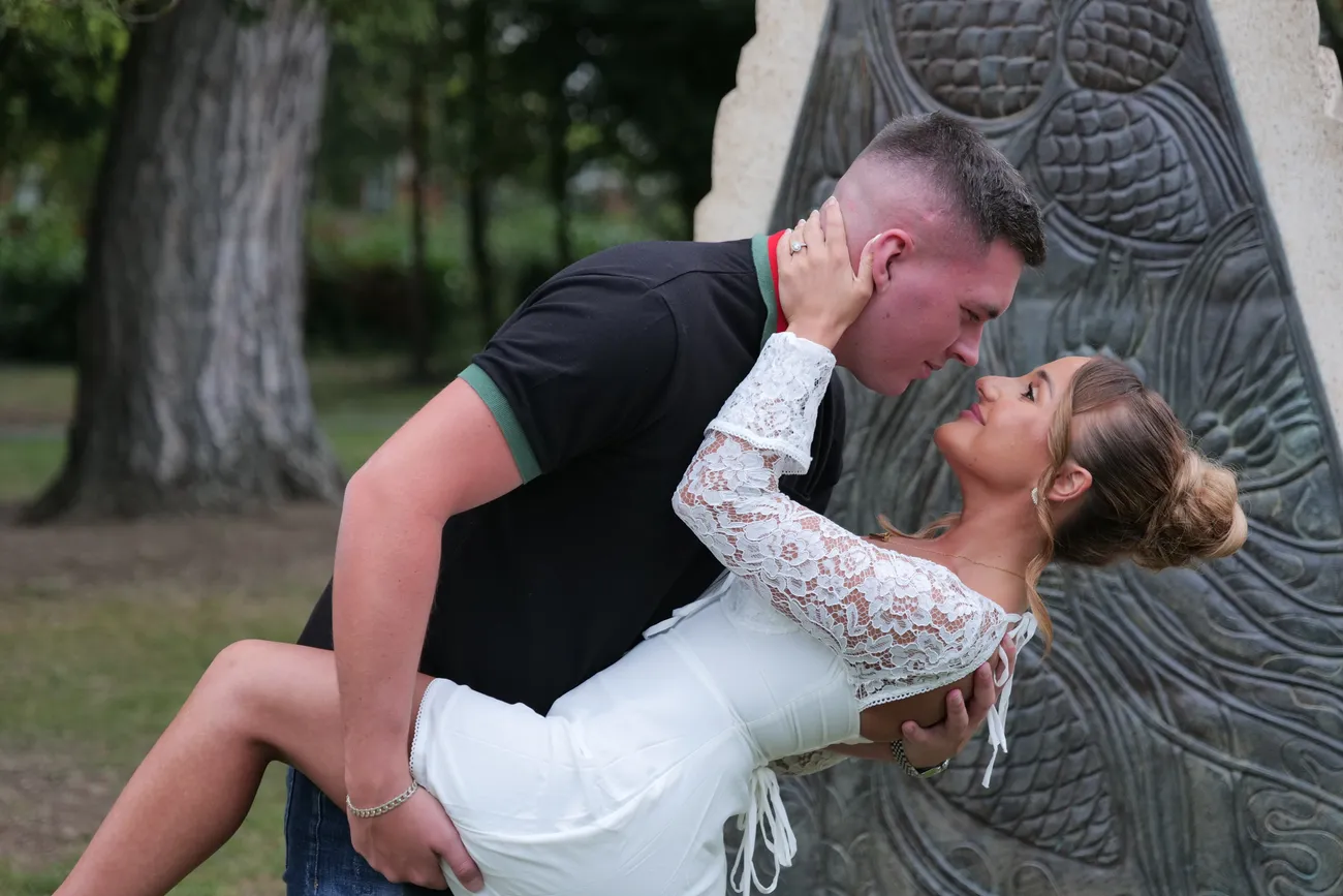Dramatic wedding dip portrait beside a carved tree