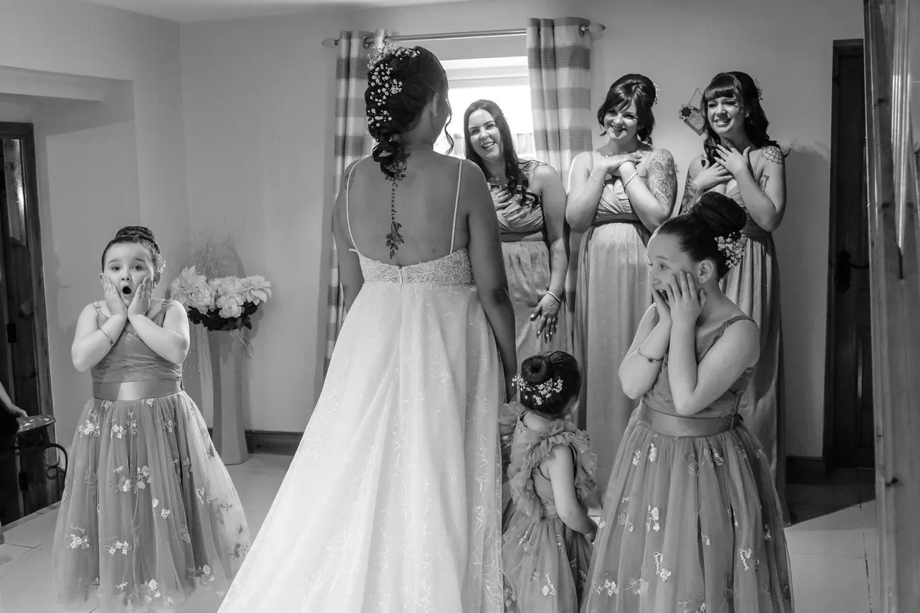 Flower girls reacting as they see the bride in her dress