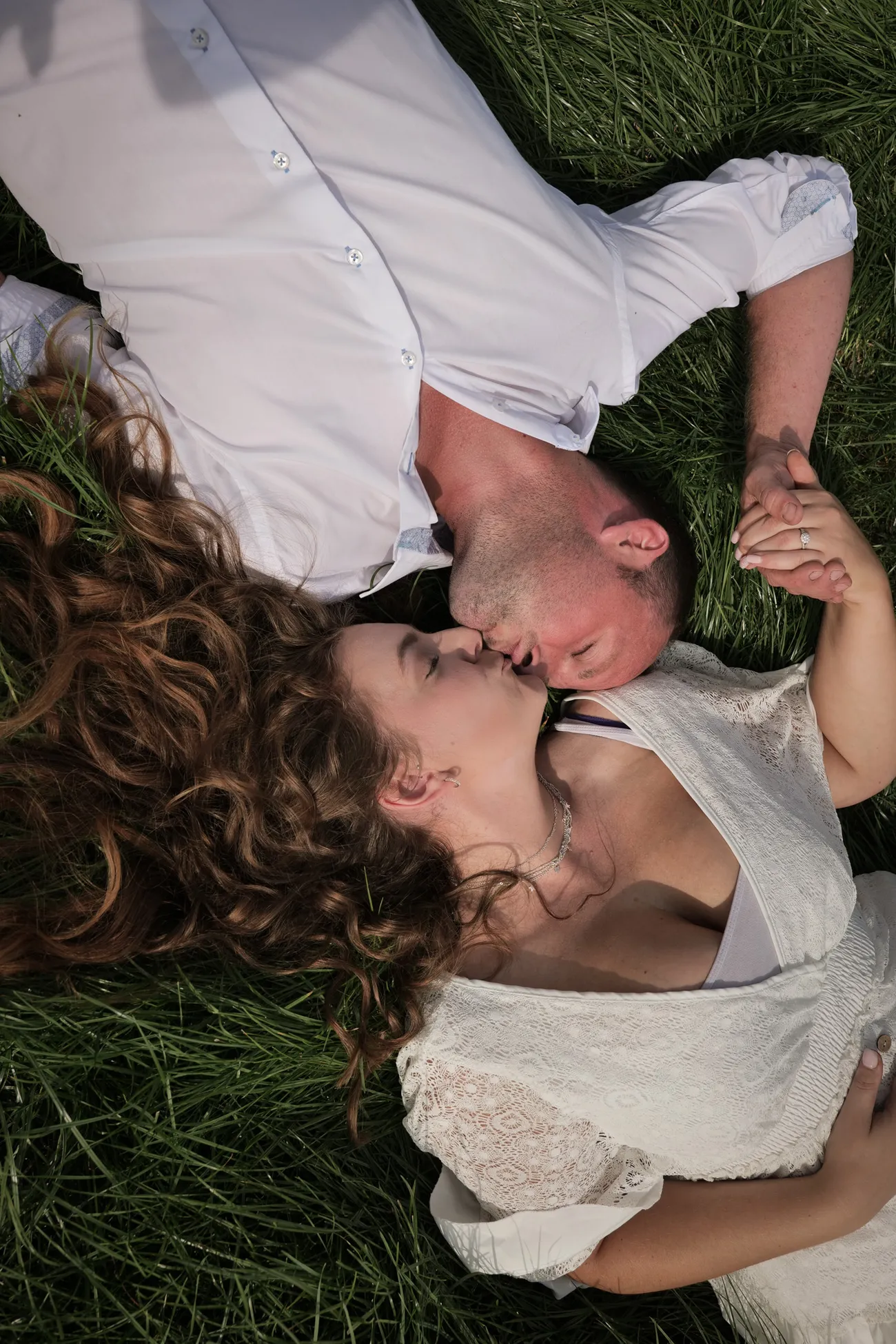 Couple lying together in grass for a wedding portrait