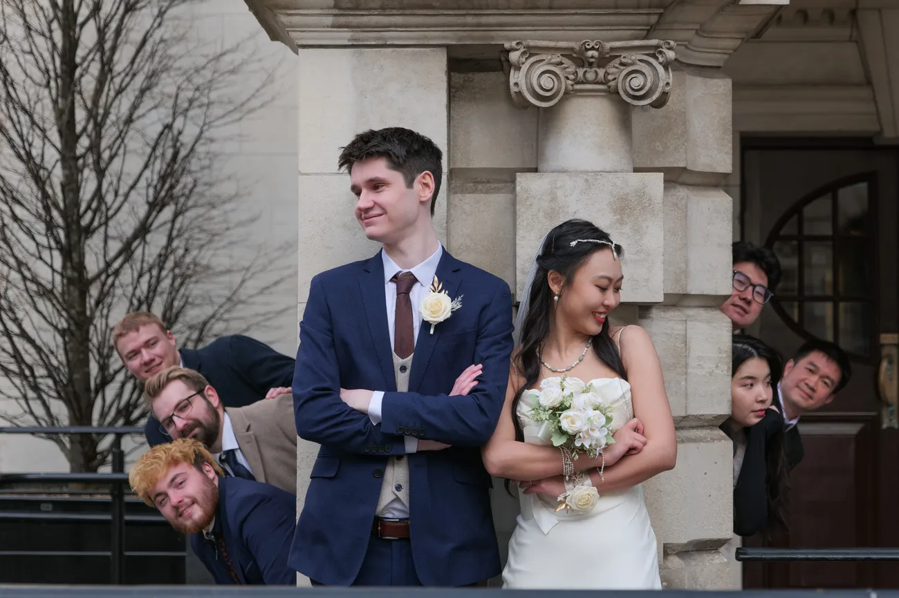 Playful bridal party portrait outside a city hall