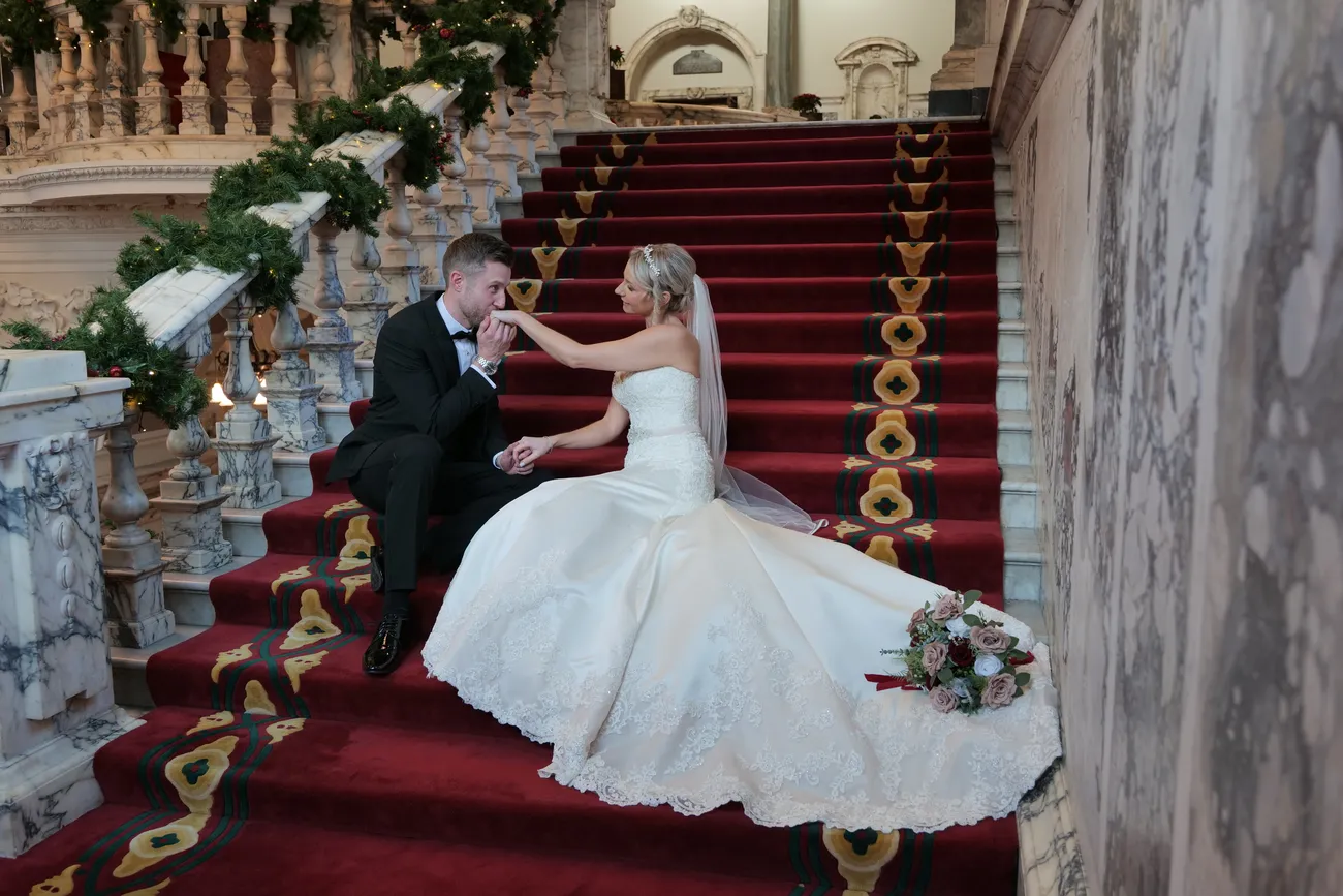 Wedding kiss on a grand red staircase