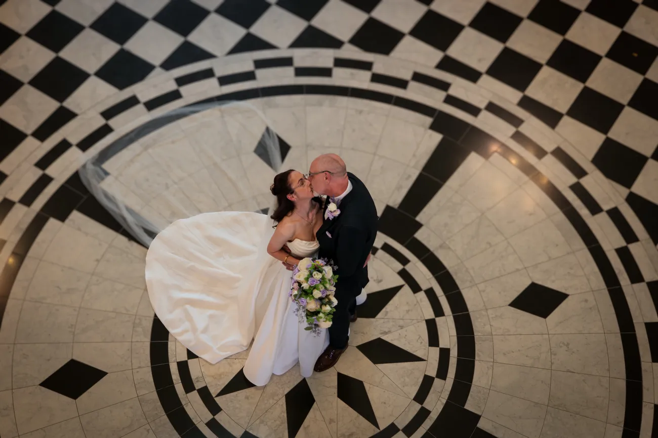 Overhead wedding kiss on a tiled floor